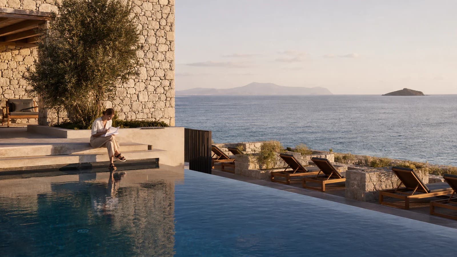 Travel editor reviewing a property record beside a quiet adults-only coastal resort pool in the early morning